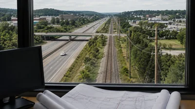 A highway, railroad, and utility corridor viewed above rolled intercity fiber route plans